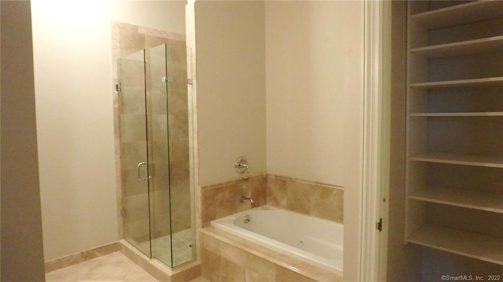 75 Stone Ridge Way, Unit 3E Fairfield, CT 06824 - Photo 8 of 23 Primary bathroom with marble floor and shower. Relax in a whirlpool tub after hard day's work.