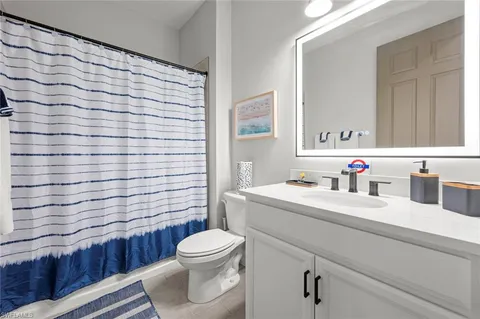a bathroom with a sink a toilet and shower curtain