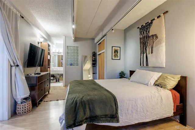 a bedroom with a bed a television and a large window