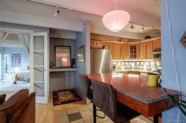a kitchen with stainless steel appliances granite countertop a stove and a dining table