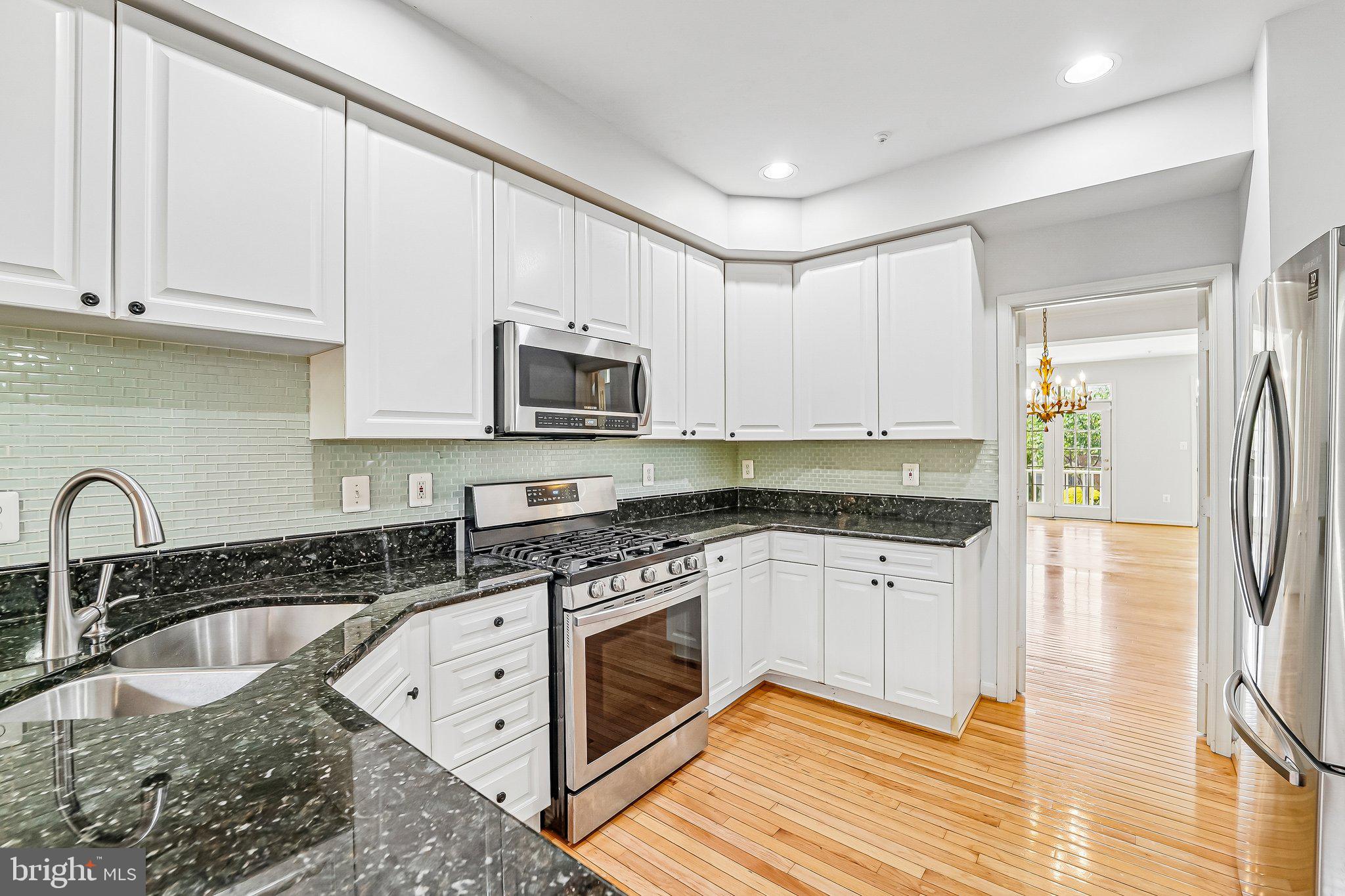 2422 Rippling Brook Road Frederick, MD 21701 - Photo 7 of 35 a kitchen with granite countertop a stove a sink and a microwave