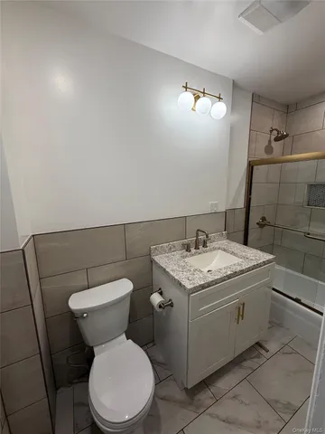 a bathroom with a granite countertop toilet and a sink