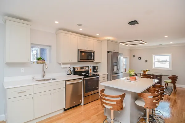 a kitchen with a sink a stove a refrigerator and chairs