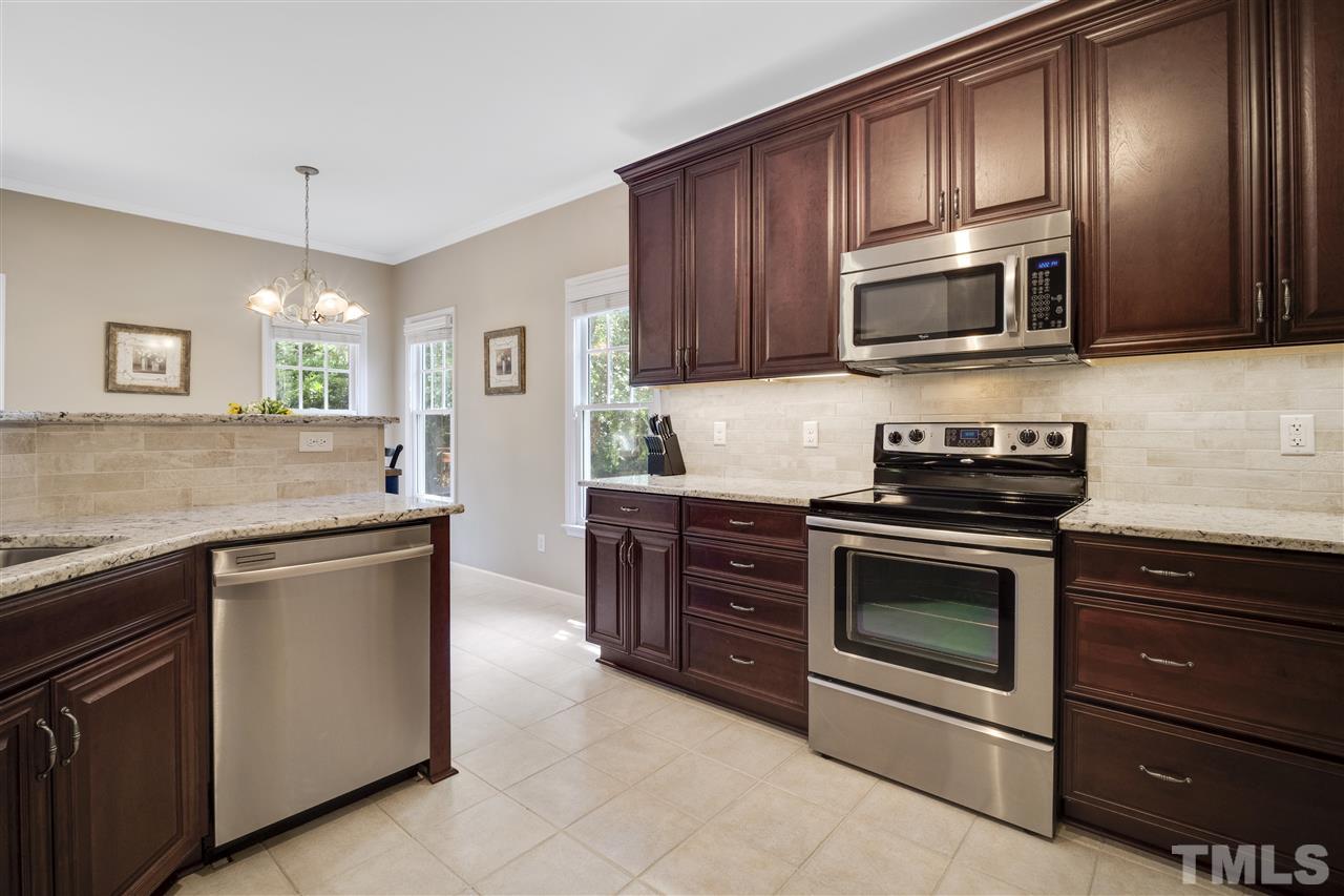 10228 River Bank Drive Raleigh, NC 27614 - Photo 6 of 29 a kitchen with stainless steel appliances granite countertop a stove microwave and refrigerator