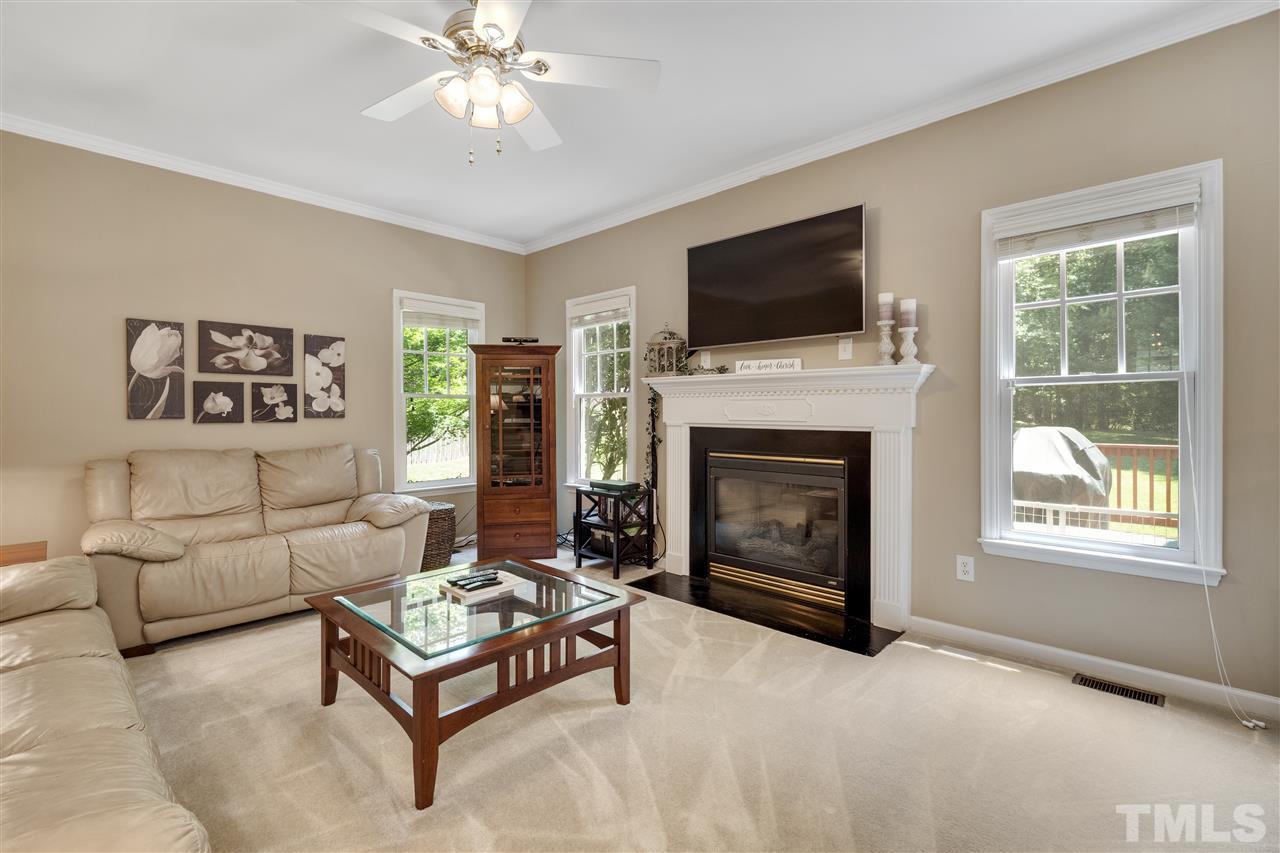 10228 River Bank Drive Raleigh, NC 27614 - Photo 10 of 29 a living room with furniture a flat screen tv and a fireplace