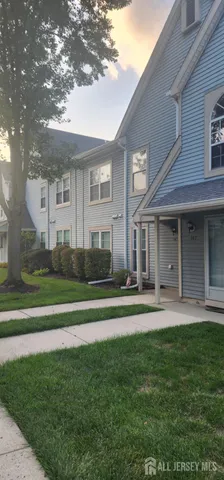 a front view of a house with a garden and trees