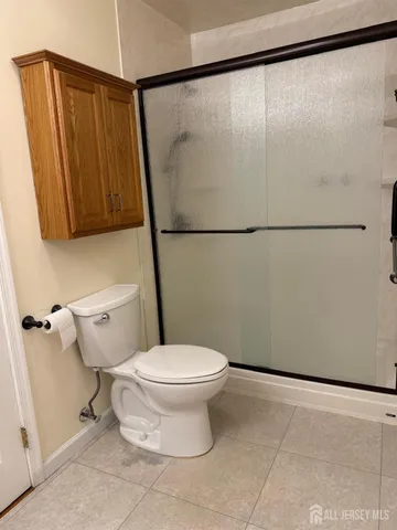 a white toilet sitting next to a shower
