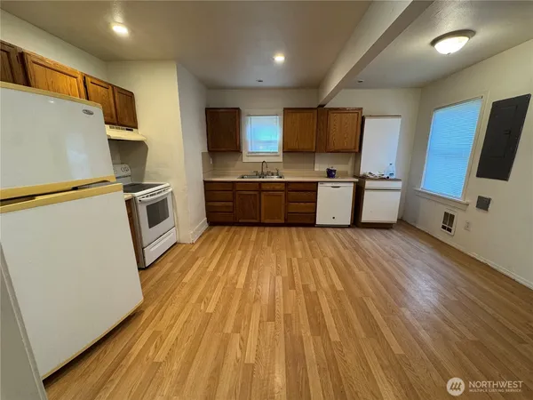 a large kitchen with stainless steel appliances a large counter top a stove a sink dishwasher and a refrigerator