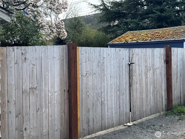 a wooden bench sitting in front of a wooden fence