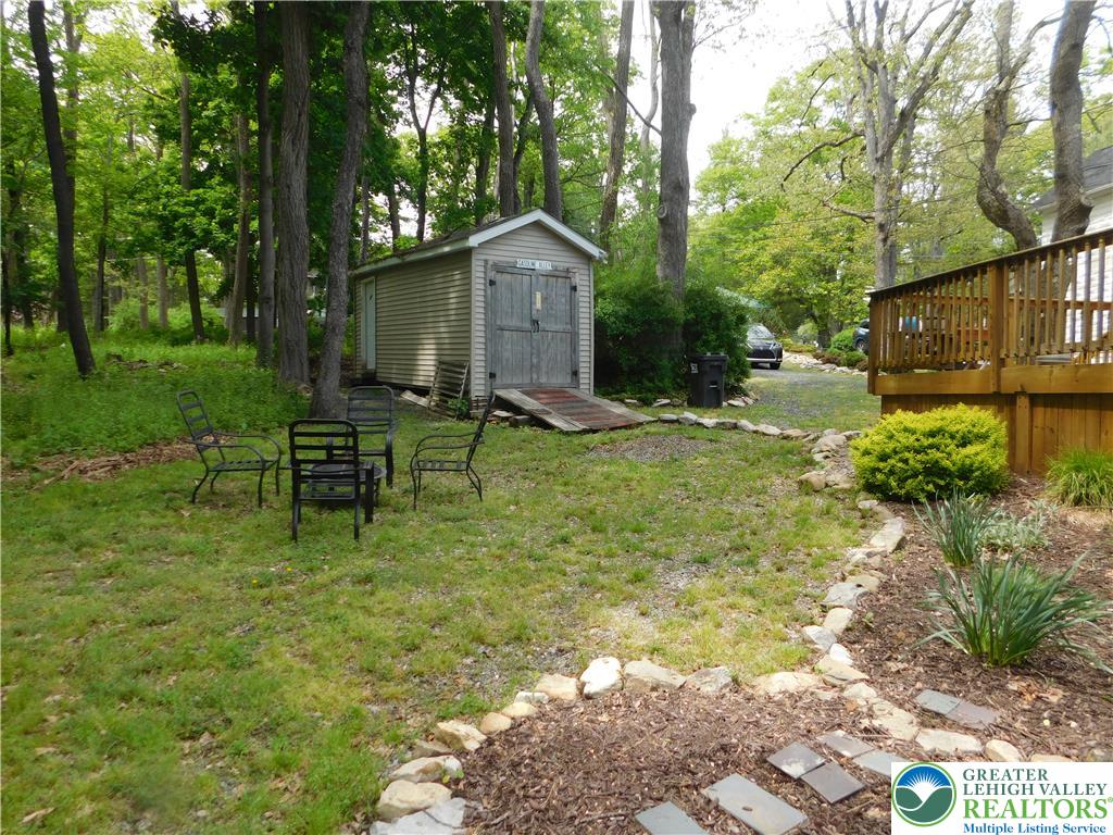 41 Reeder Street Mount Pocono, PA 18344 - Photo 13 of 41 A private yard with a charming shed and a spacious wooden deck offers serene outdoor living.