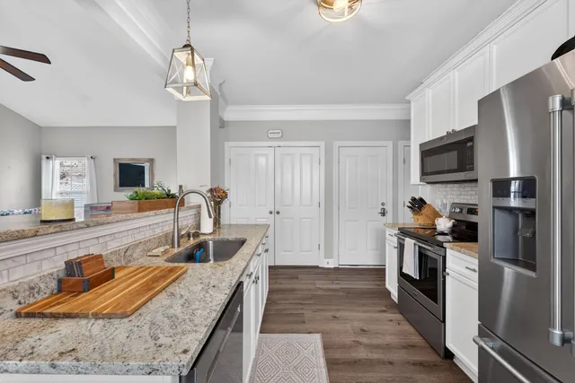 a kitchen with stainless steel appliances granite countertop a refrigerator and a stove top oven