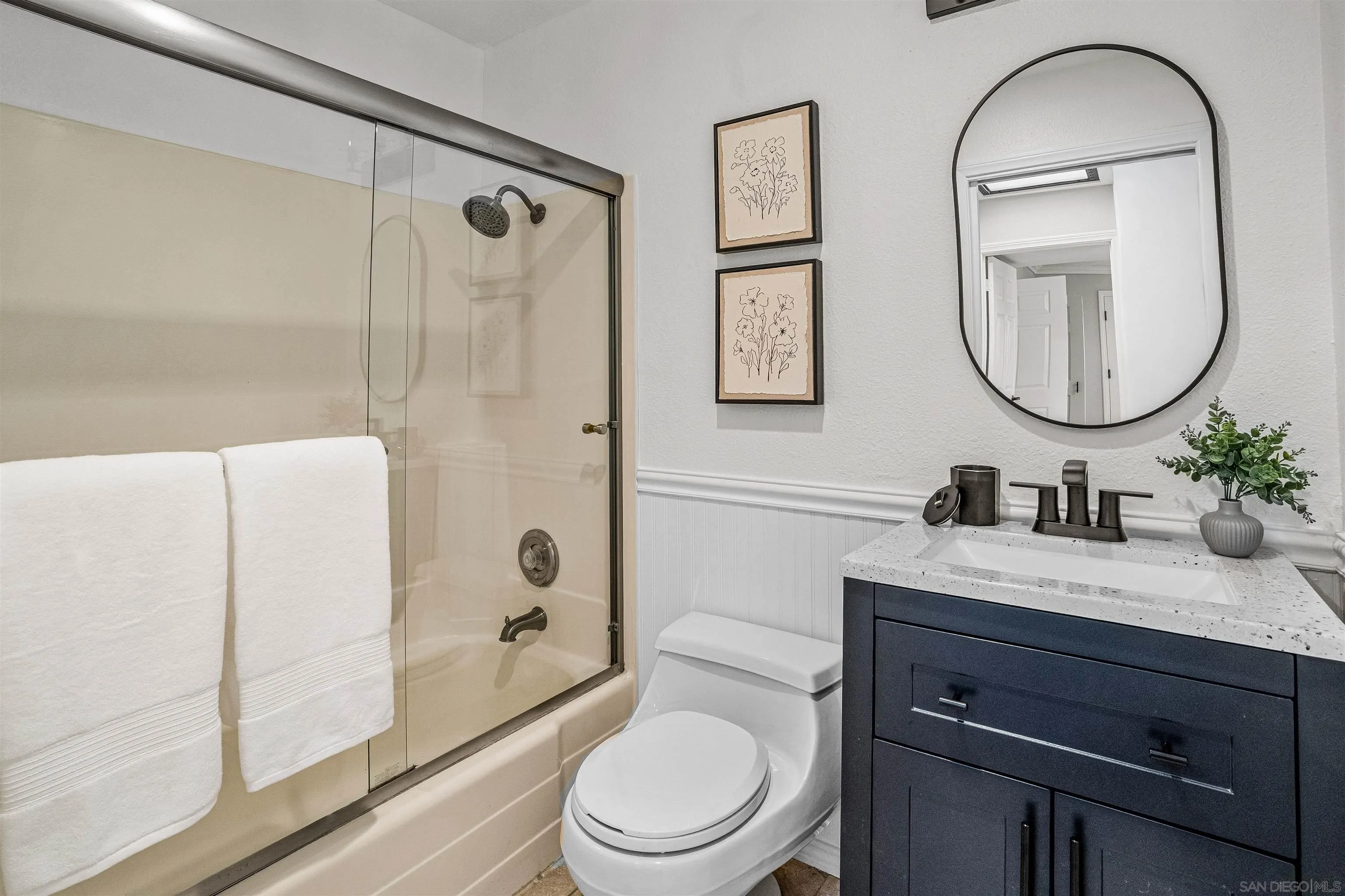 3926 Voltaire Street San Diego, CA 92107 - Photo 16 of 30 a bathroom with a granite countertop toilet a sink and a mirror
