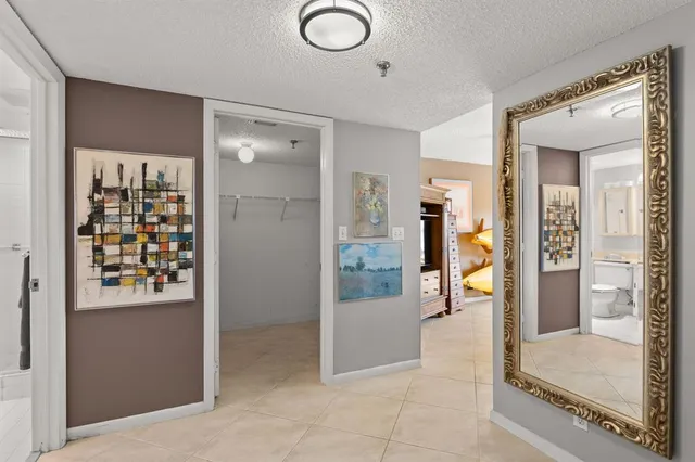 a view of a hallway with bathroom and glass door