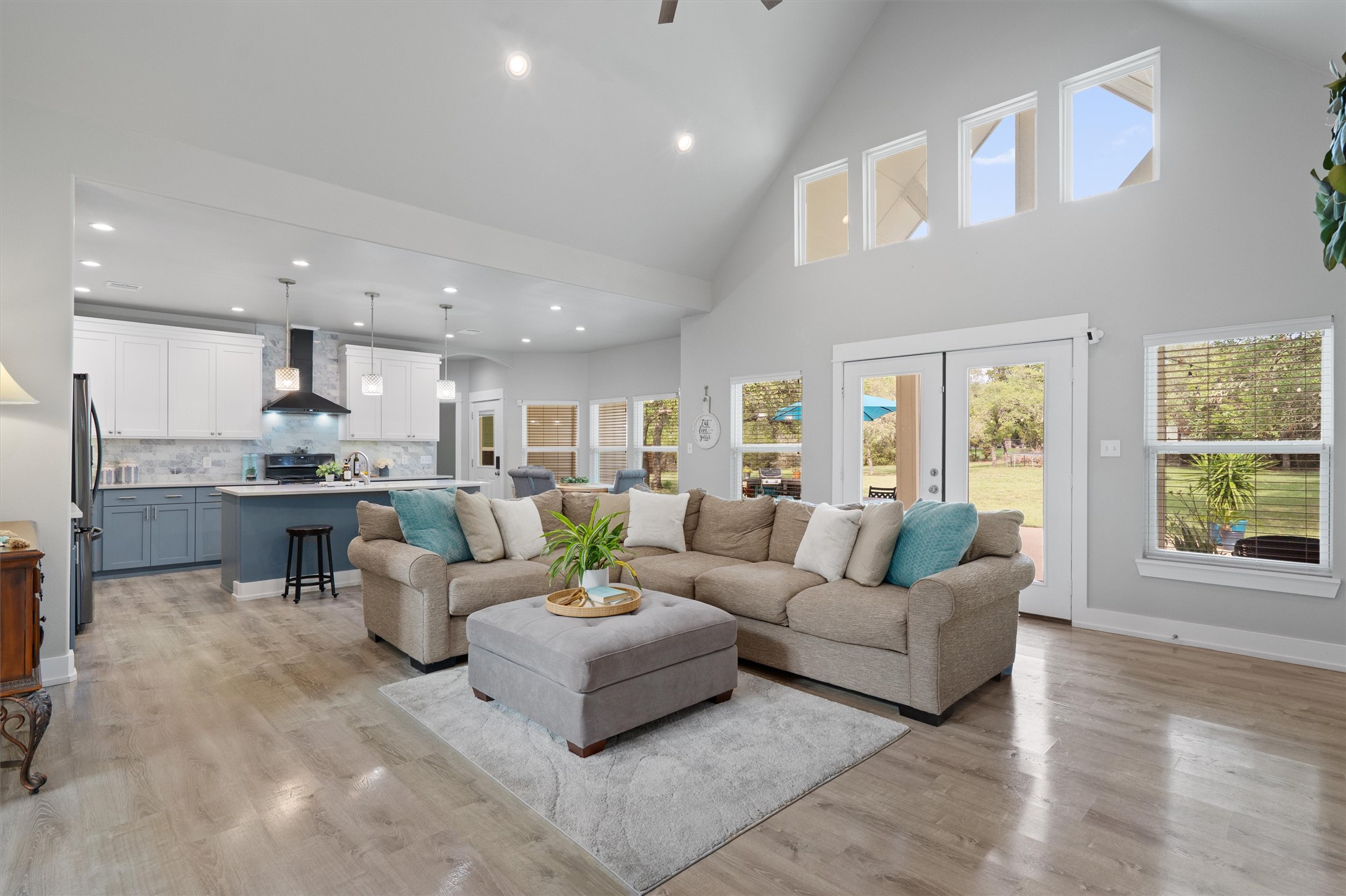 13105 Rooster Springs Road Austin, TX 78737 - Photo 3 of 38 This open concept living space features a vaulted ceiling, light-toned flooring, and ample natural light from several windows and glass doors