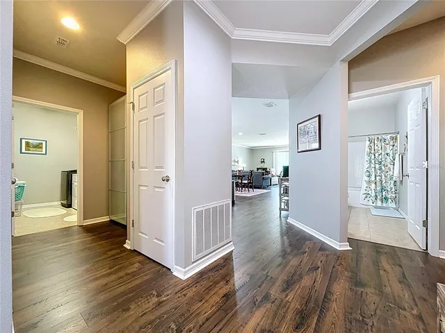 a view of a hallway with wooden floor and a living room