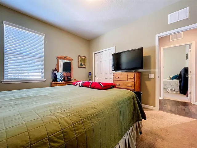 a bedroom with a bed and a flat screen tv