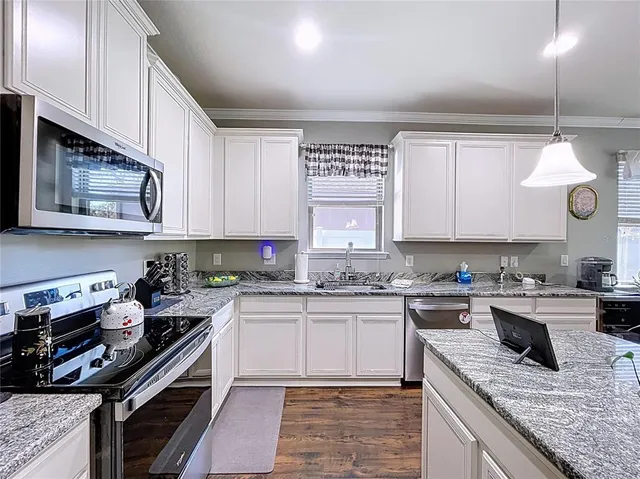 a kitchen with a stove cabinets and window