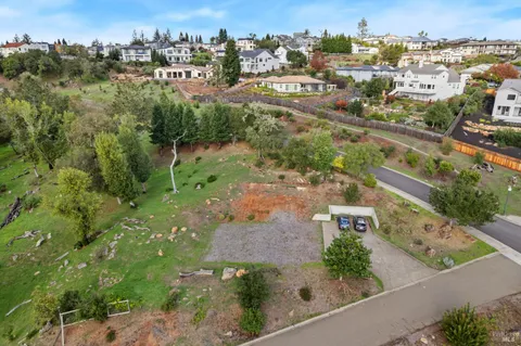 an aerial view of residential houses with outdoor space and trees