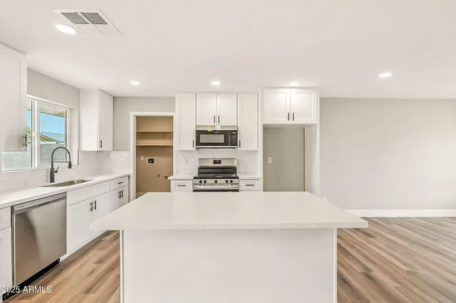 a kitchen with stainless steel appliances a refrigerator sink and stove