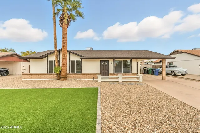 a front view of a house with a garden and yard