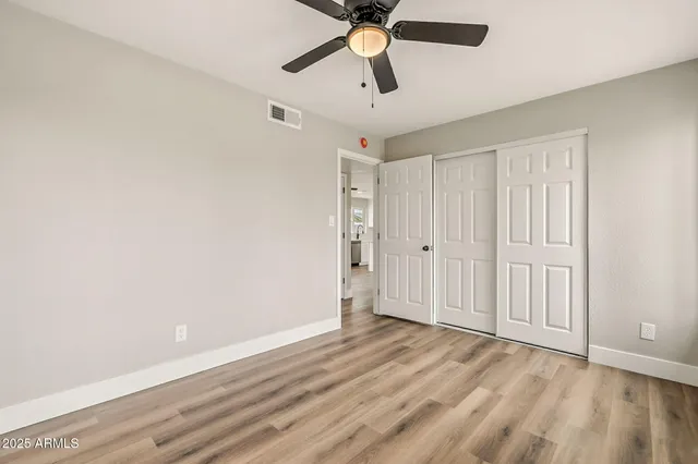 a view of empty room with wooden floor