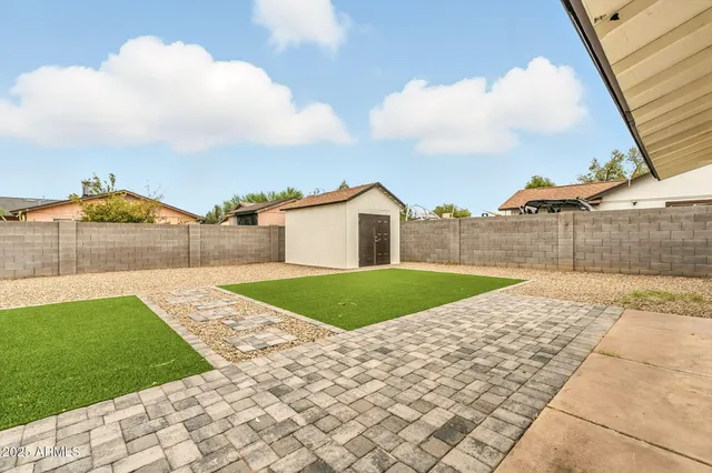 a view of backyard of house and car parked