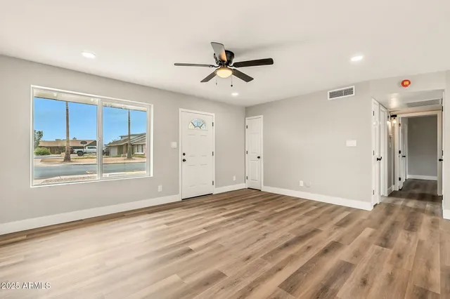 a view of an empty room with window and cabinet