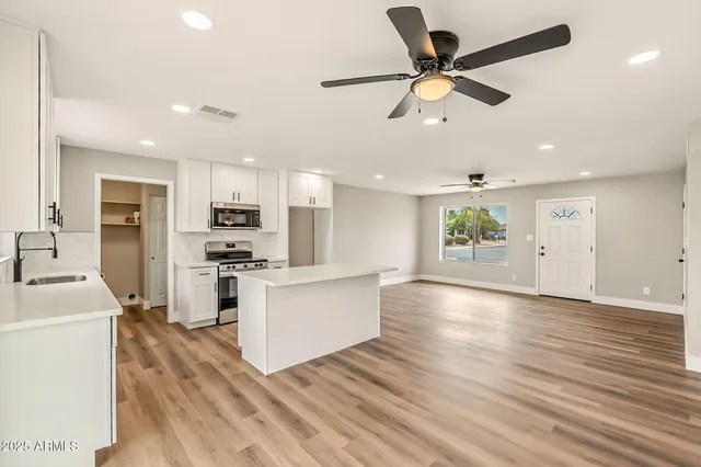 a view of kitchen with cabinets microwave and stove