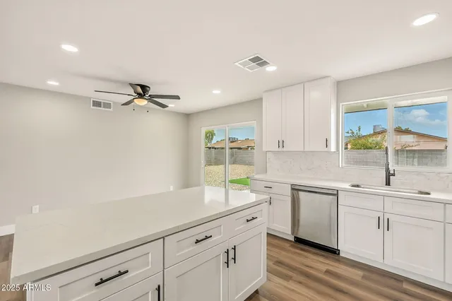 a kitchen with white cabinets and sink