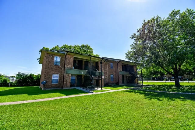 a view of a house with backyard and a tree