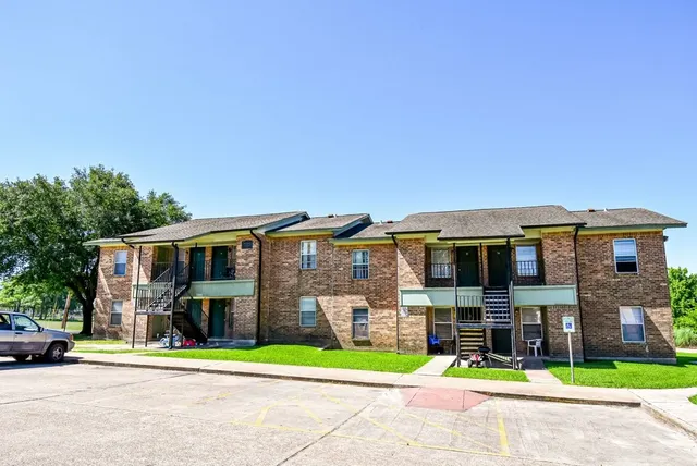 a front view of residential houses with yard and green space