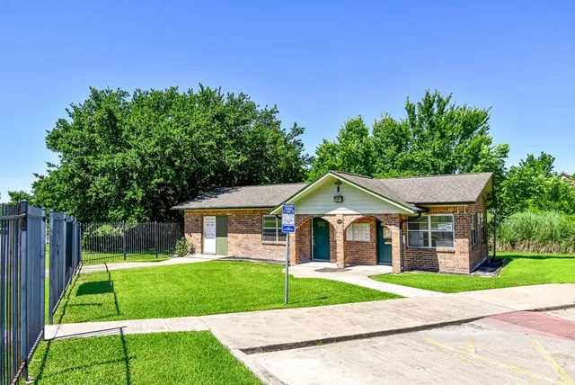 a view of house with a big yard plants and large trees