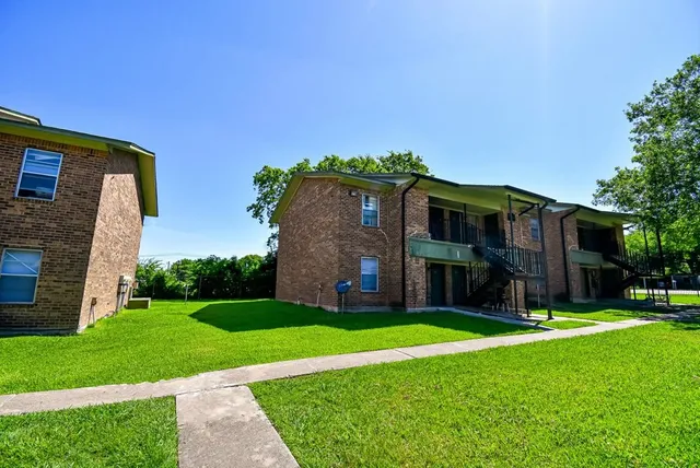 a view of a house with a big yard and large tree
