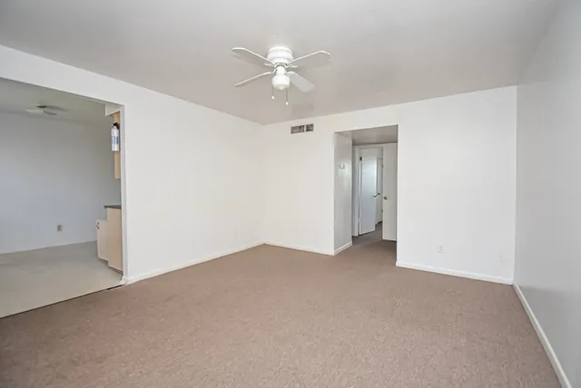 a view of an empty room with a ceiling fan