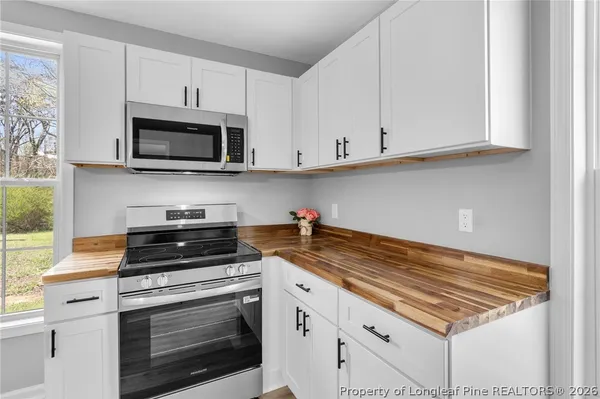 a kitchen with white cabinets and appliances