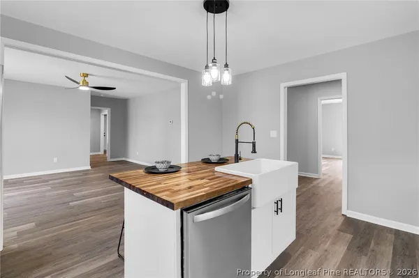 a view of kitchen island with granite countertop sink and wooden floor