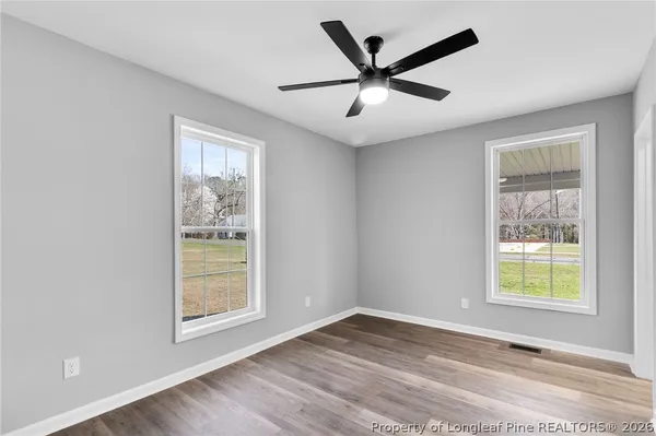 a view of a big room with wooden floor and windows
