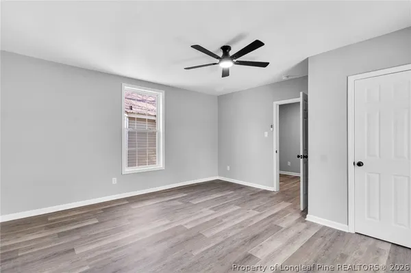 a view of a big room with wooden floor closet and windows