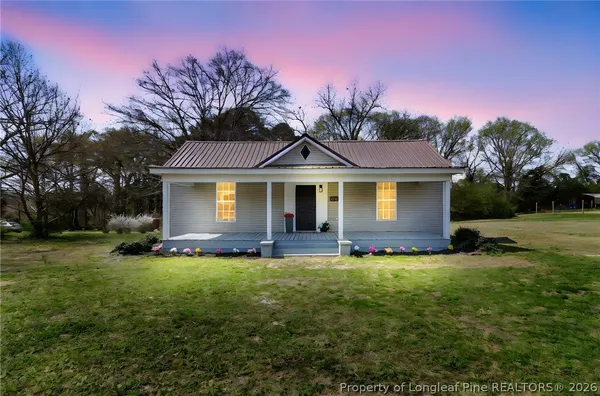 a front view of a house with a garden and yard