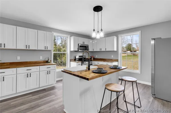 a kitchen with stainless steel appliances granite countertop a sink a stove and a refrigerator