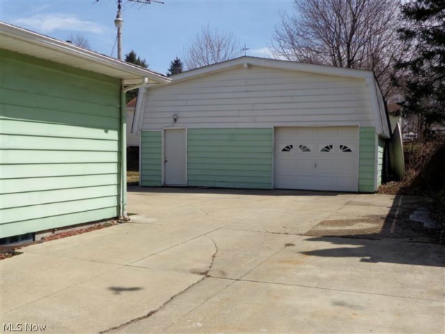 Here is a view of the over-sized 1 car garage with man door and lots of cement for parking.
