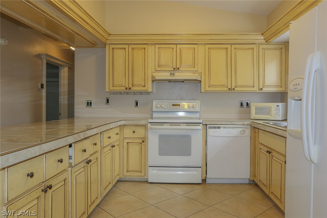 8430 Cardinal Road Fort Myers, FL 33967 - Photo 2 of 19 a kitchen with granite countertop white cabinets stainless steel appliances a sink and a counter top space