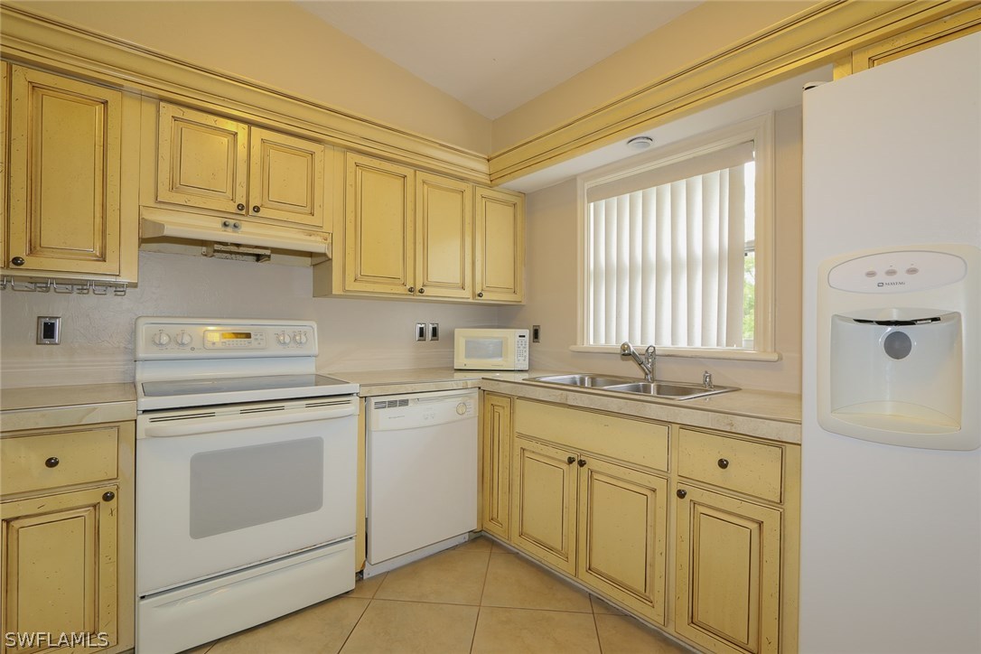 8430 Cardinal Road Fort Myers, FL 33967 - Photo 7 of 19 a kitchen with white cabinets and white appliances