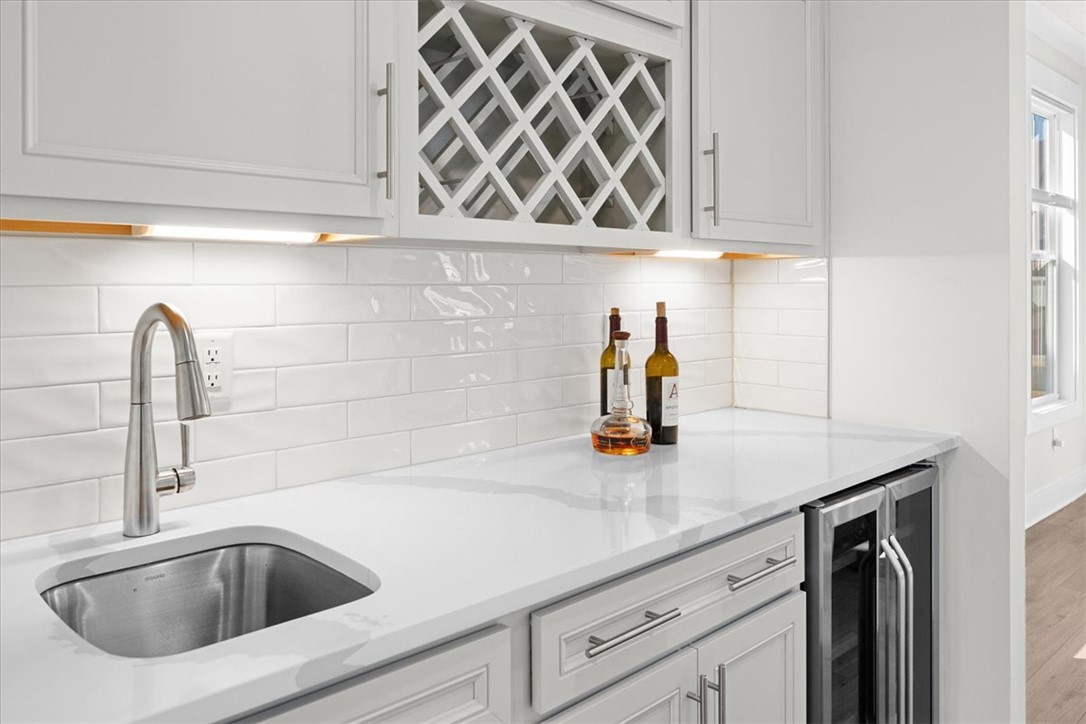 621 Wh Kay Lane Anderson, SC 29621 - Photo 13 of 50 A Fabulous wet bar offers convenience and style for entertaining, featuring a sink, subway tile backsplash, and wine storage.