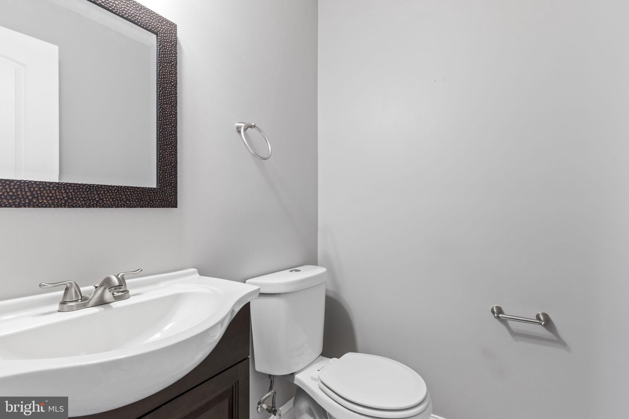 625 Savage Street Baltimore, MD 21224 - Photo 7 of 26 a bathroom with a sink a toilet and mirror