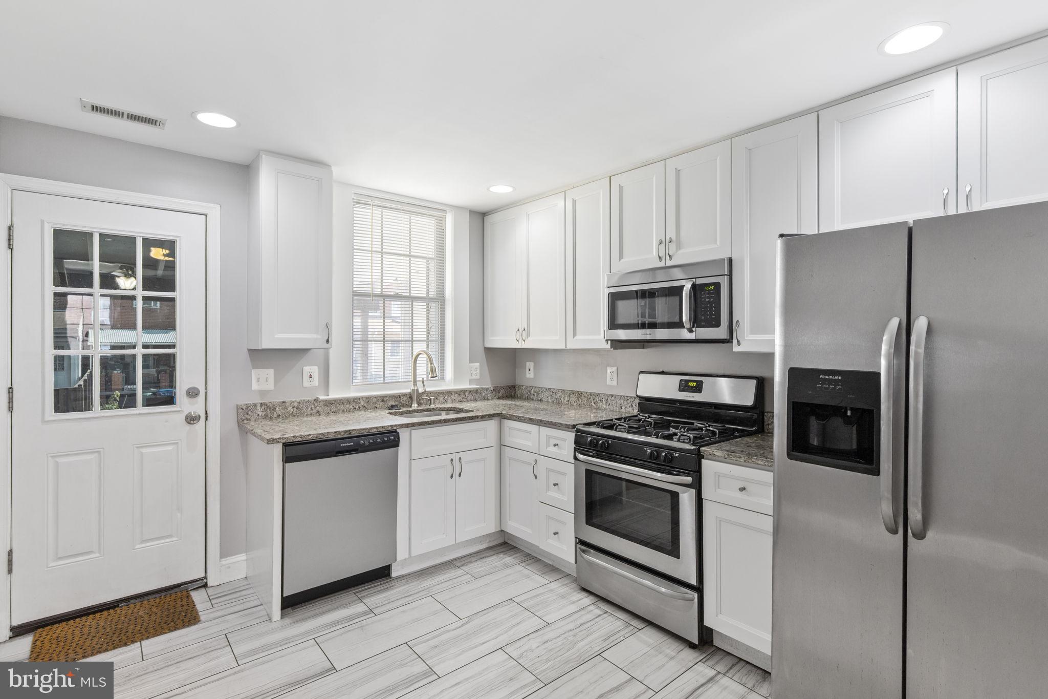 625 Savage Street Baltimore, MD 21224 - Photo 8 of 26 a kitchen with cabinets stainless steel appliances and window