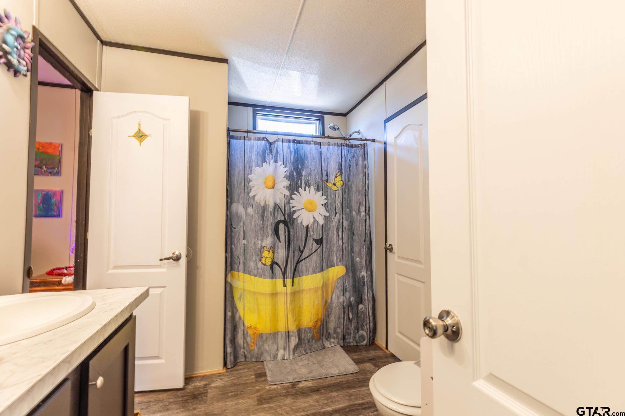 182 Sioux Quitman, TX 75783 - Photo 13 of 14 a bathroom with a sink mirror vanity and toilet