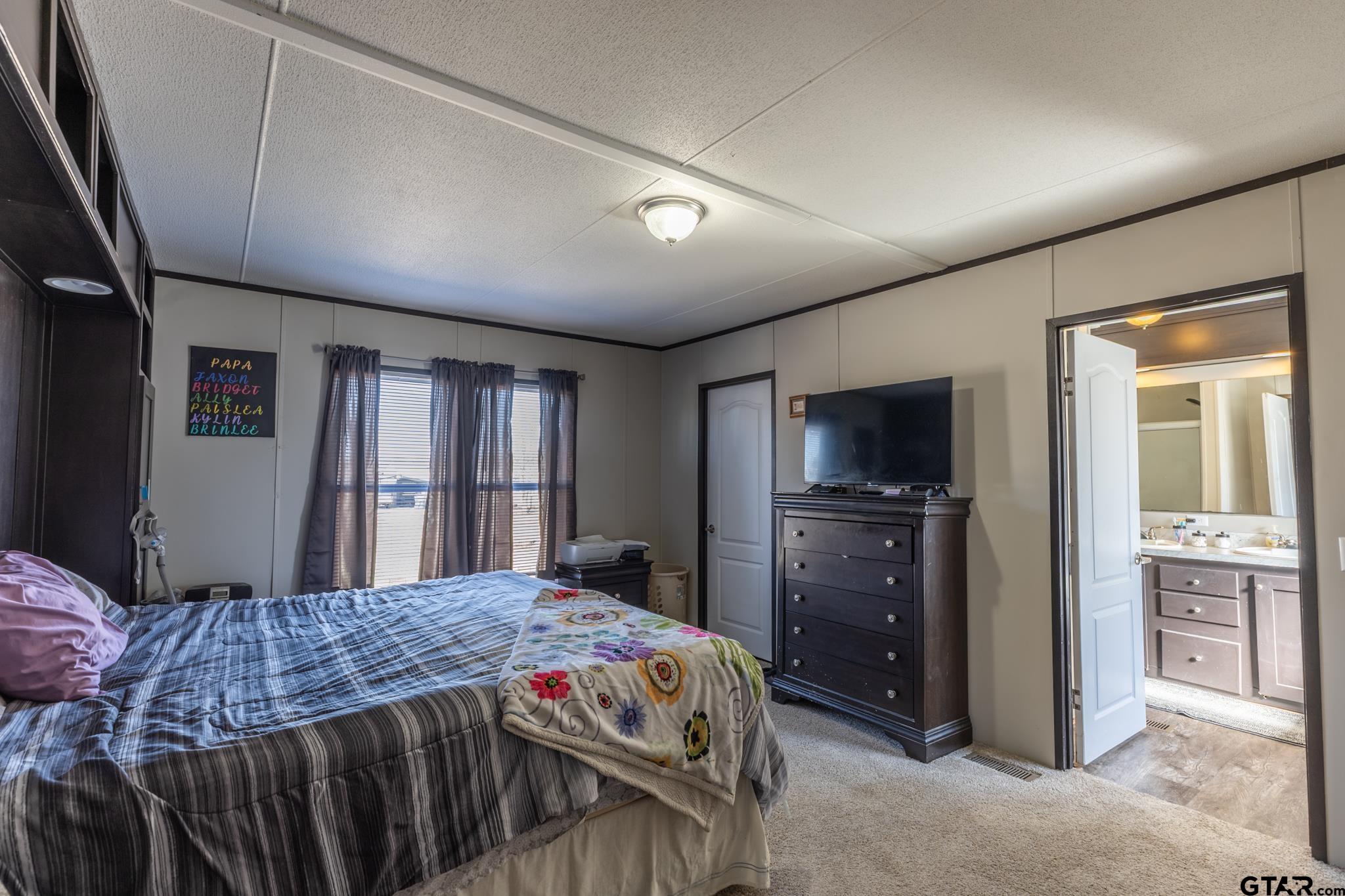 182 Sioux Quitman, TX 75783 - Photo 9 of 14 a bedroom with a bed and a dresser with mirror