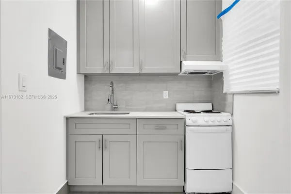 a kitchen with cabinets appliances a sink and a window