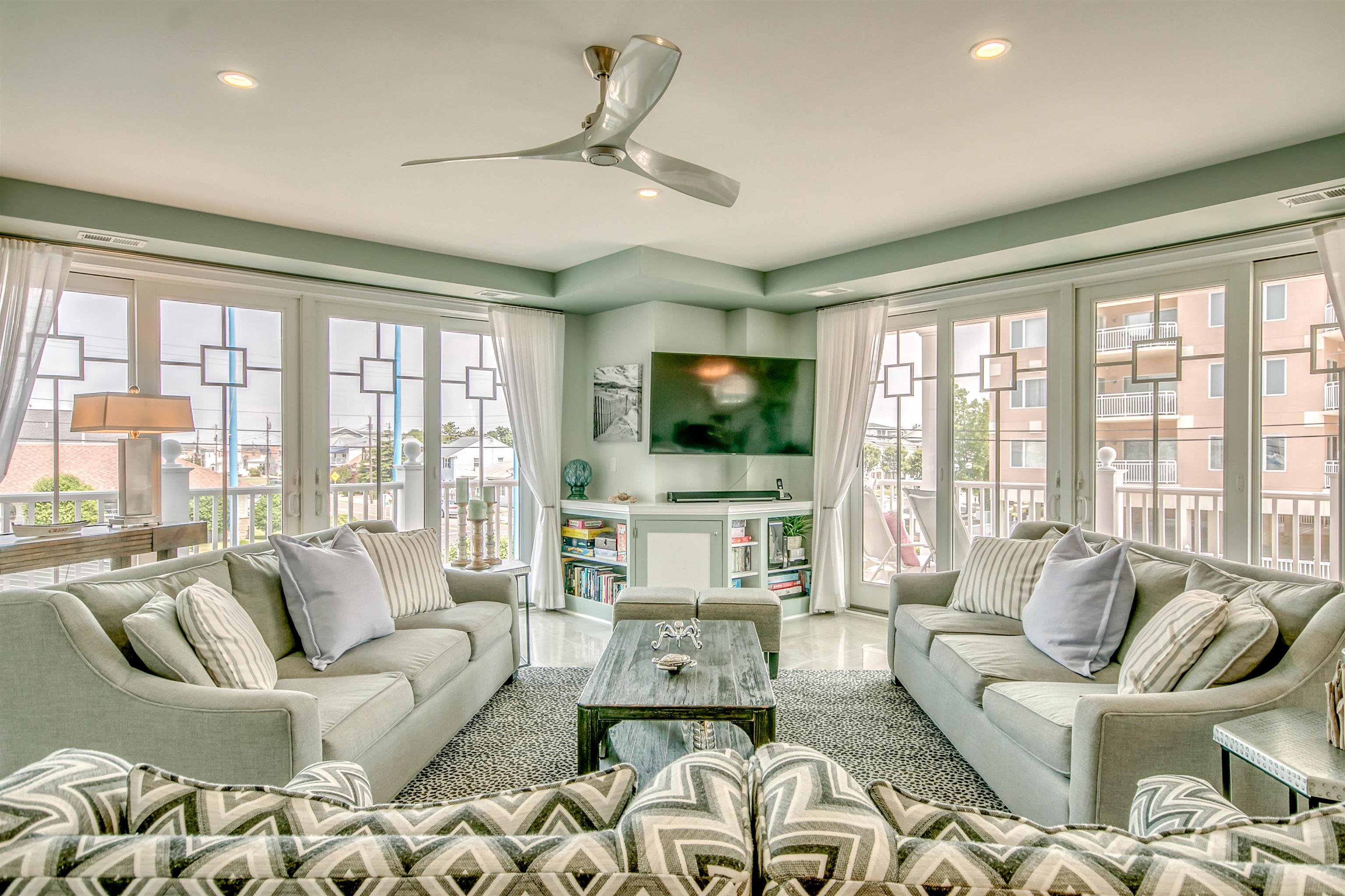 7701 Atlantic Avenue, Unit 102 Wildwood Crest, NJ 08260 - Photo 3 of 25 a living room with furniture large windows and a flat screen tv